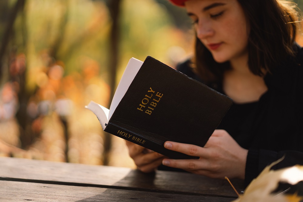 Christian teen girl holds bible in her hands. Reading the Holy Bible ...