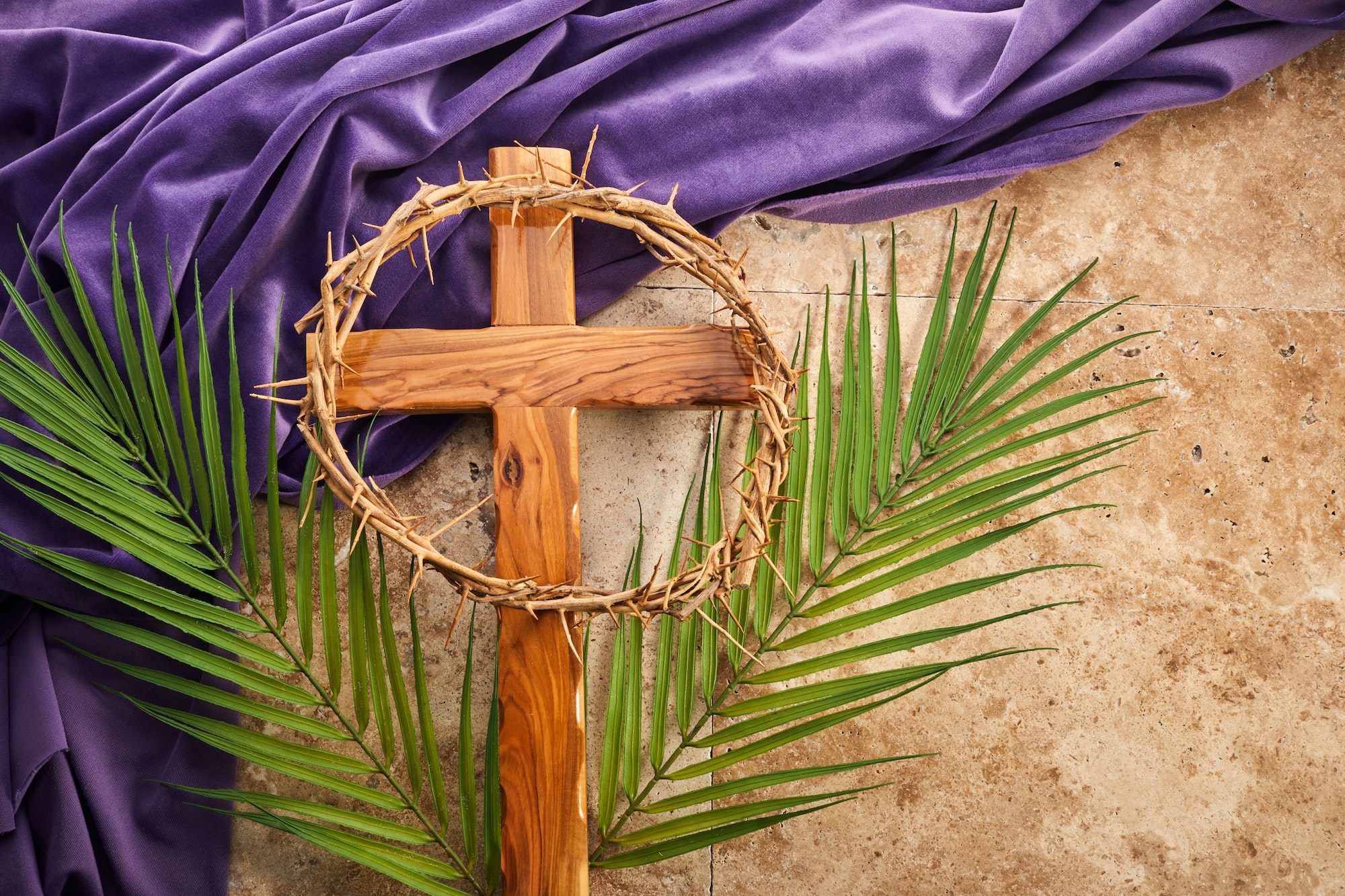 Lent season, Holy week and Good friday concept. Palm leave and cross on stone background