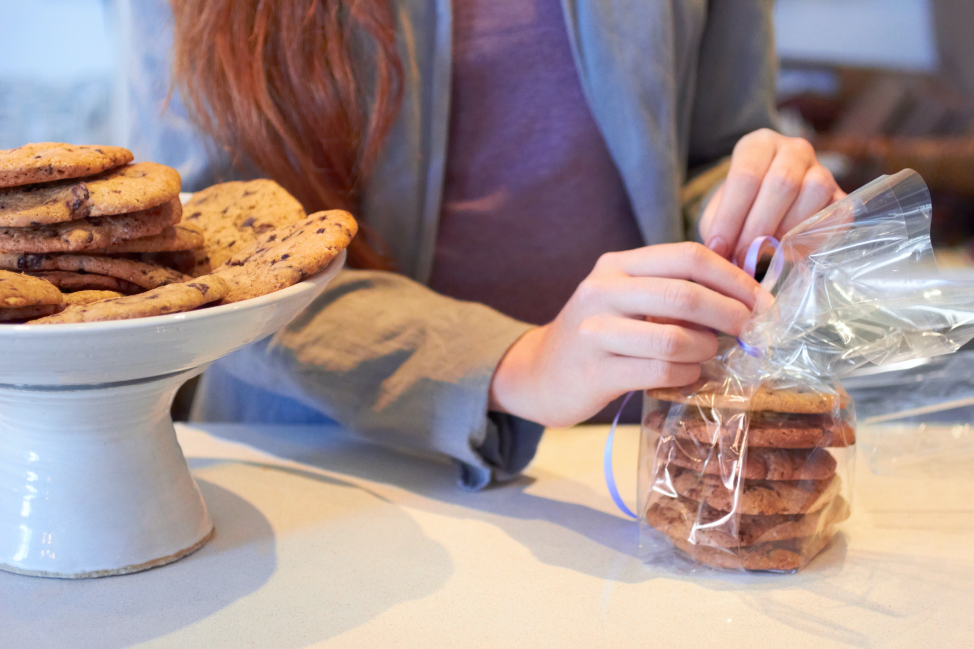 Wrapping some fresh cookies for sale. Cropped shot of a woman working in her bakery.